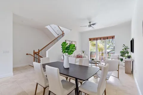 a dining room with furniture potted plants and wooden floor