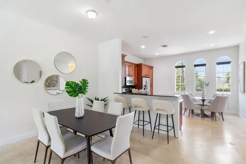 a dining room with furniture potted plants and wooden floor