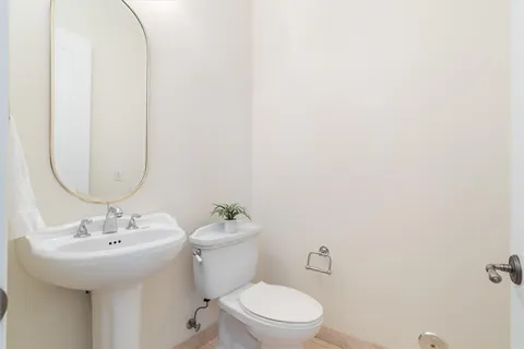 a bathroom with a toilet a sink and mirror