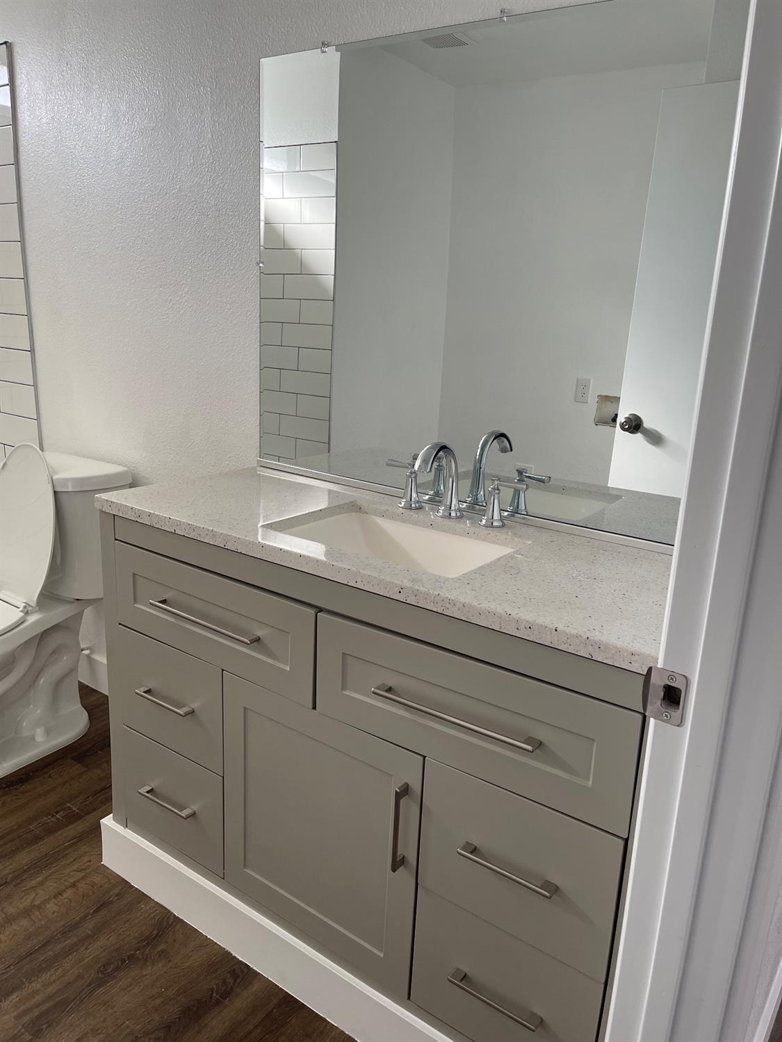 405 Fig Street Madera, CA 93638 - Photo 15 of 22 a bathroom with a granite countertop sink vanity mirror and toilet