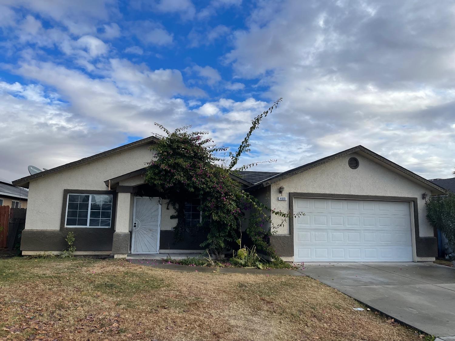 405 Fig Street Madera, CA 93638 - Photo 2 of 22 a front view of a house with a yard and garage