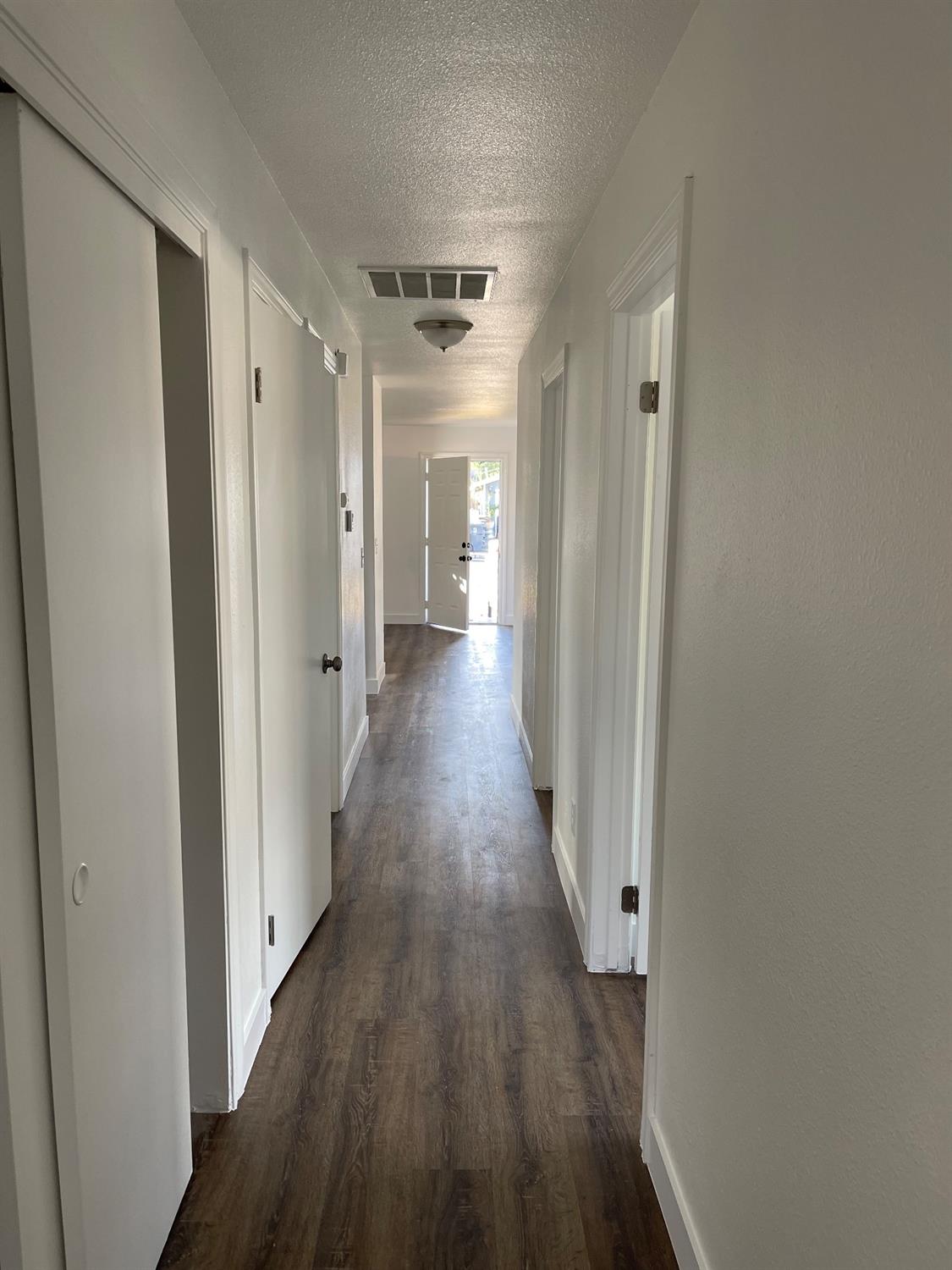 405 Fig Street Madera, CA 93638 - Photo 21 of 22 a view of a hallway with wooden floor