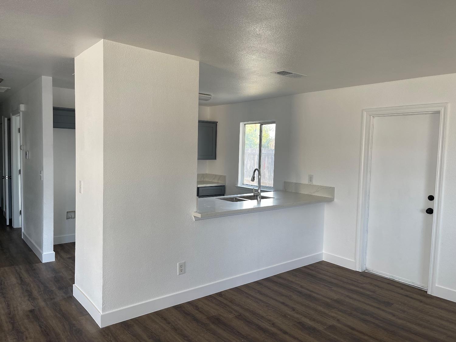 405 Fig Street Madera, CA 93638 - Photo 8 of 22 wooden floor in an empty room with a window