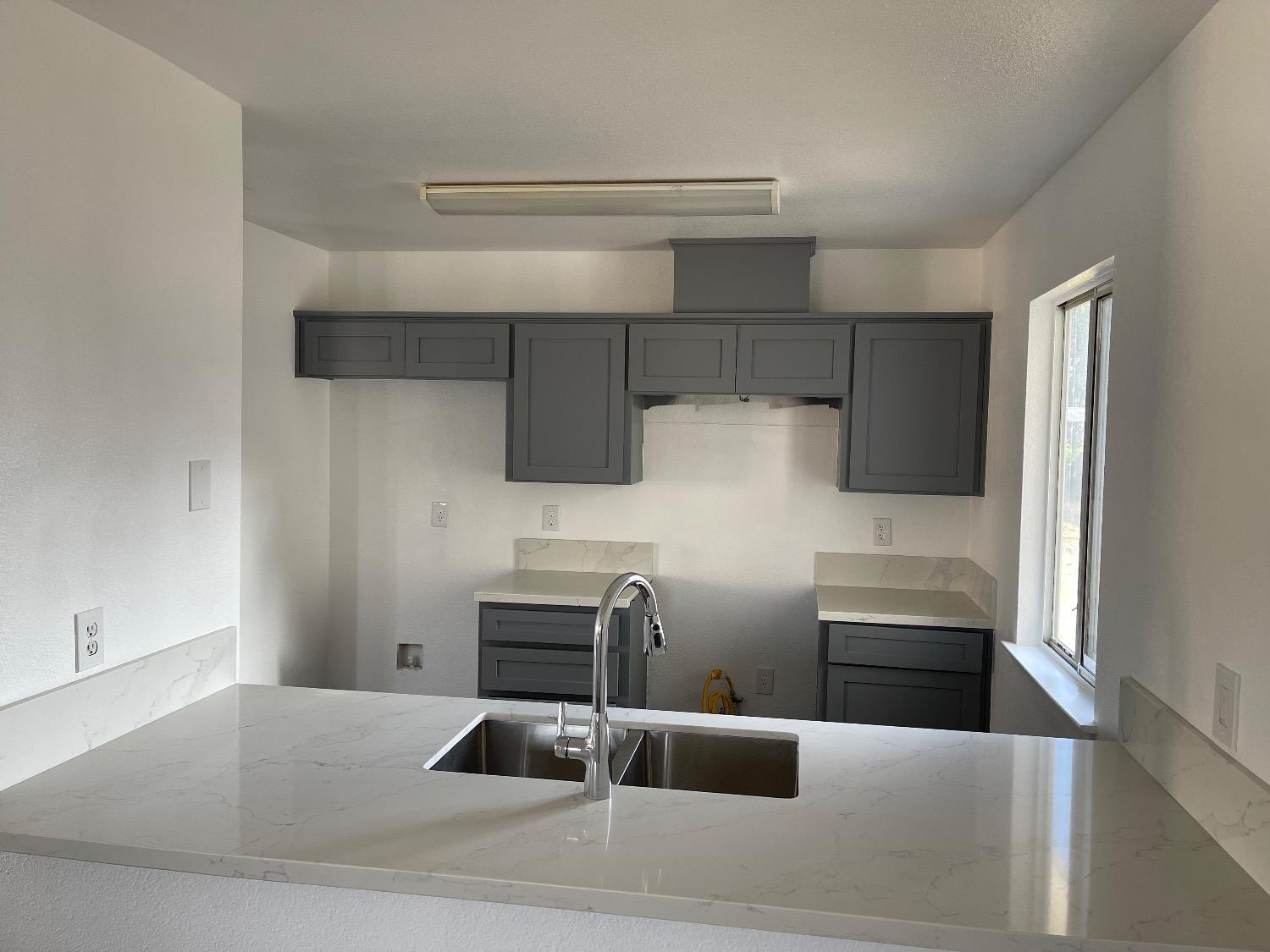 405 Fig Street Madera, CA 93638 - Photo 10 of 22 a kitchen with kitchen island stainless steel appliances a sink and cabinets