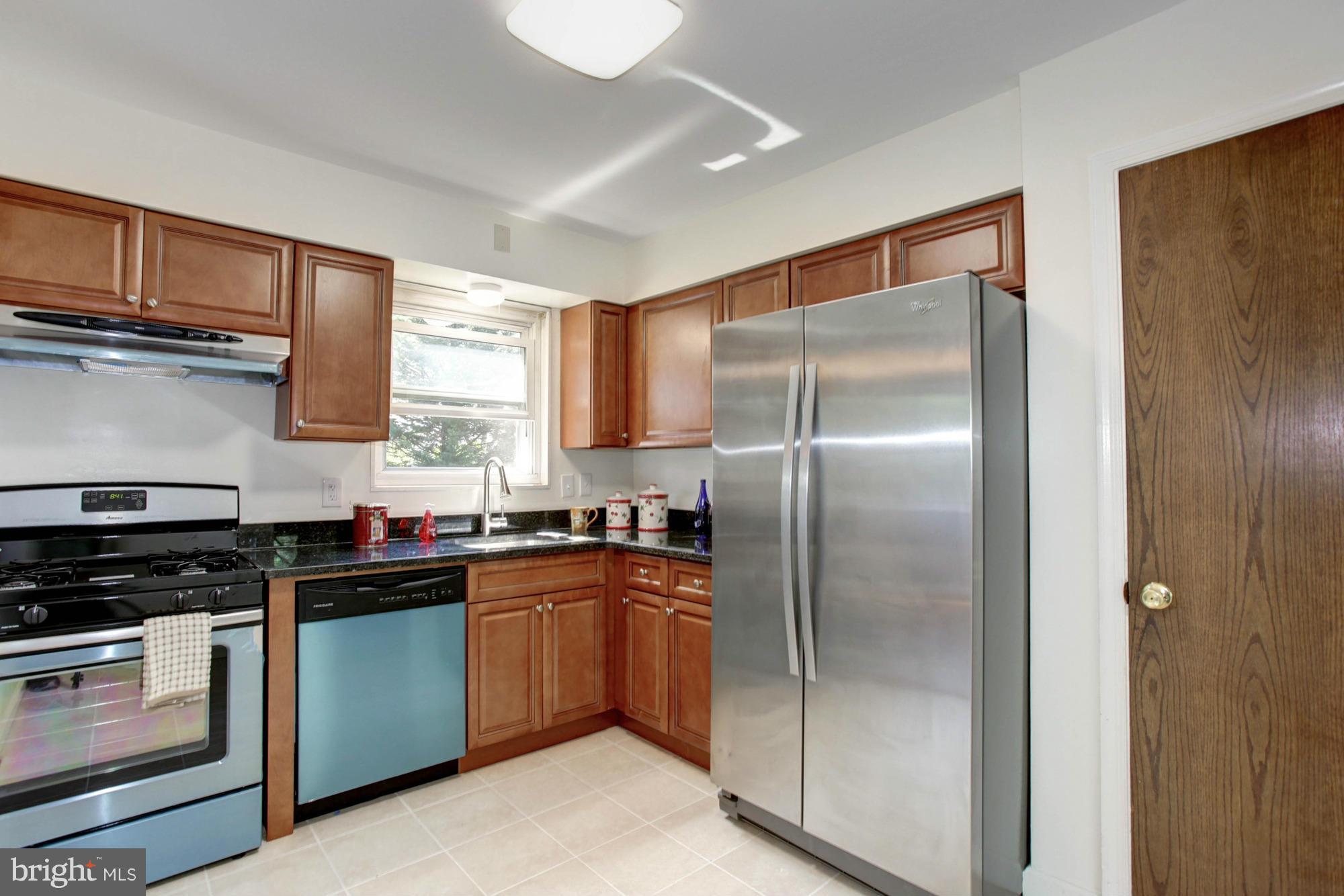 5815 Danbury Road Springfield, VA 22150 - Photo 13 of 27 a kitchen with stainless steel appliances granite countertop a refrigerator a sink a stove and cabinets
