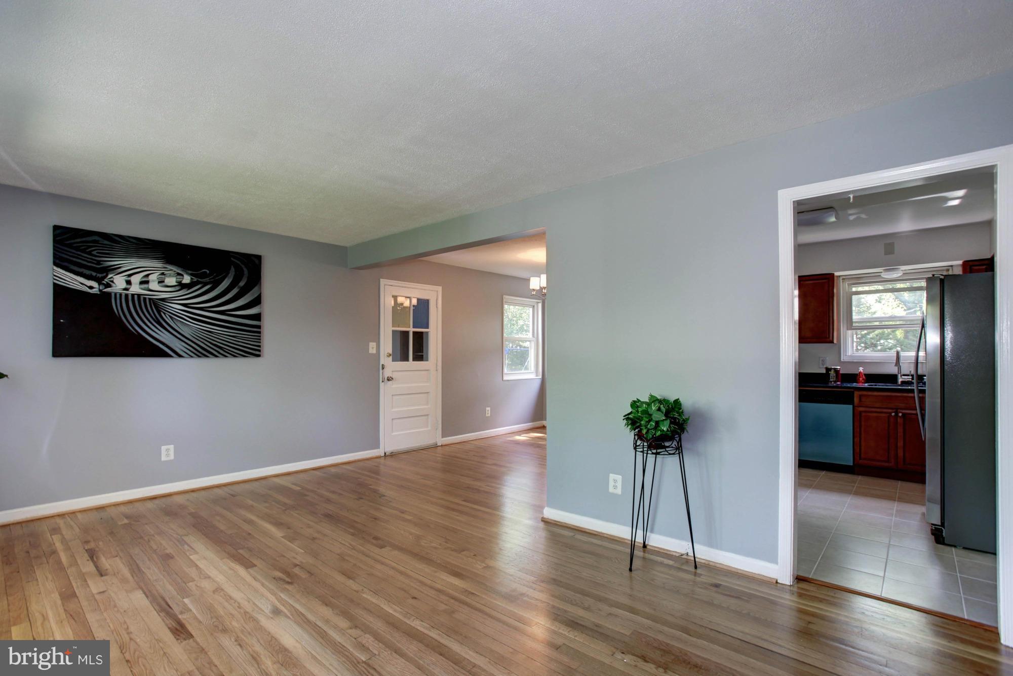 5815 Danbury Road Springfield, VA 22150 - Photo 5 of 27 a view of a hallway with wooden floor and a livingroom