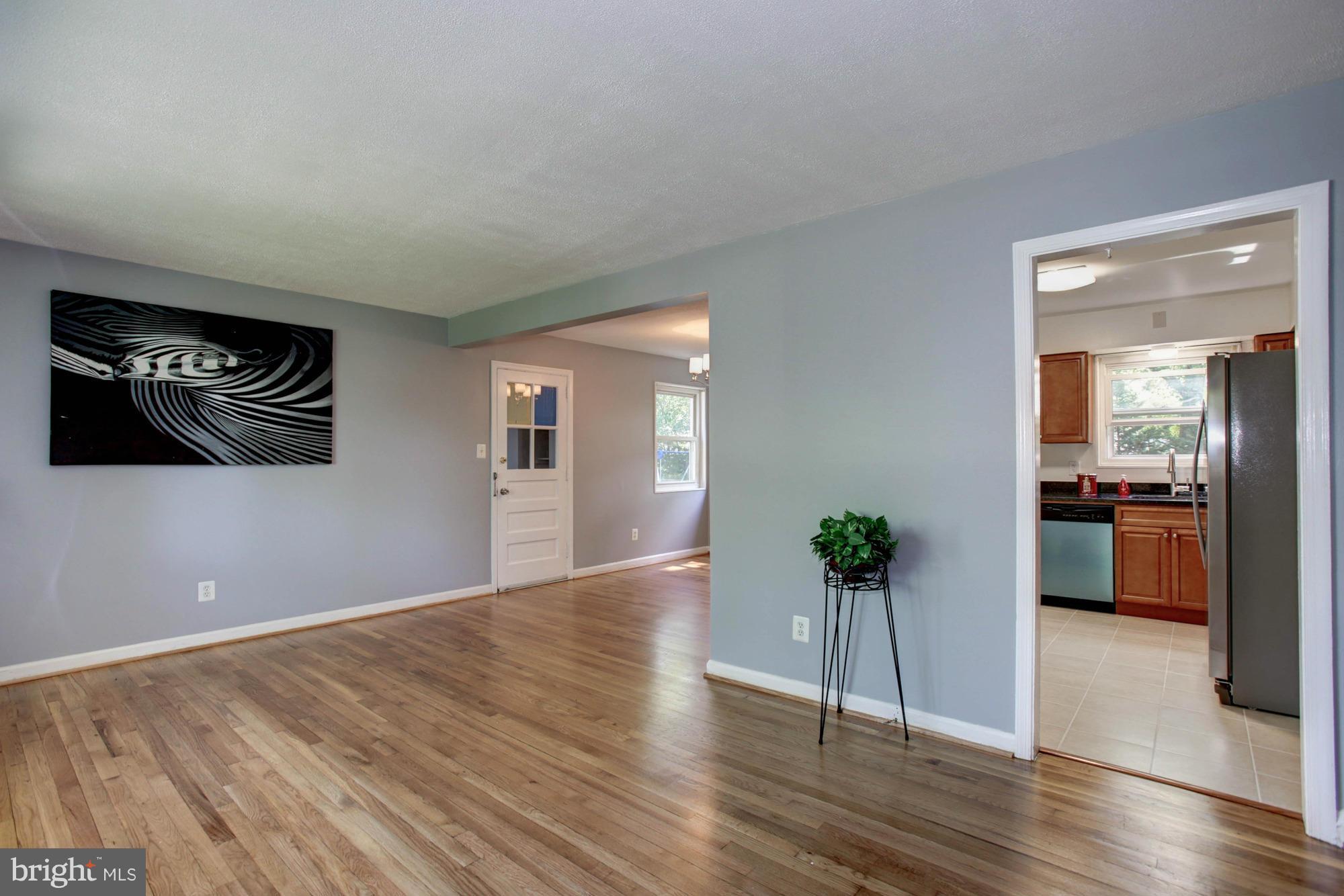 5815 Danbury Road Springfield, VA 22150 - Photo 7 of 27 a view of a livingroom with wooden floor and a kitchen