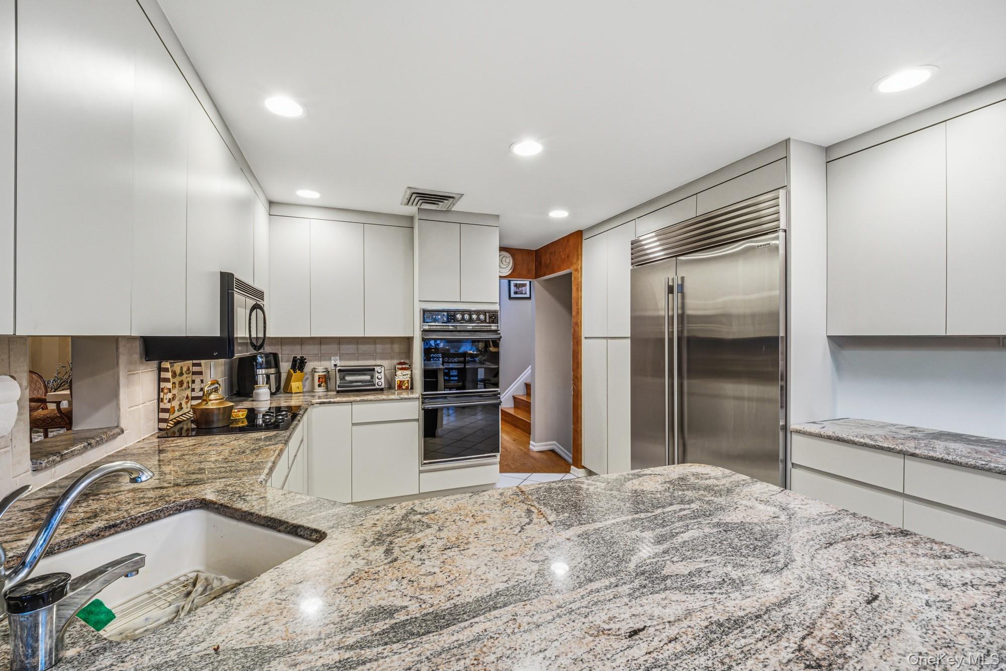 123 Robby Lane Manhasset Hills, NY 11040 - Photo 13 of 30 a kitchen with a refrigerator sink and microwave