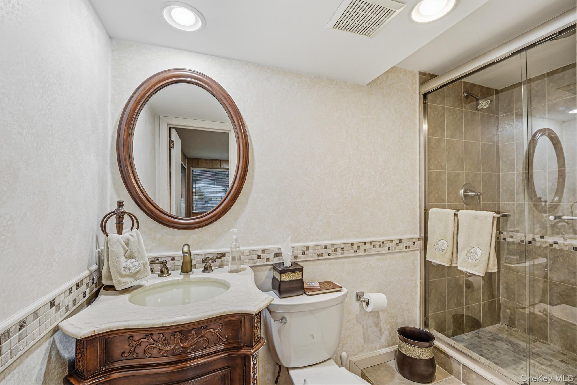 123 Robby Lane Manhasset Hills, NY 11040 - Photo 22 of 30 a bathroom with a granite countertop toilet a sink and a mirror
