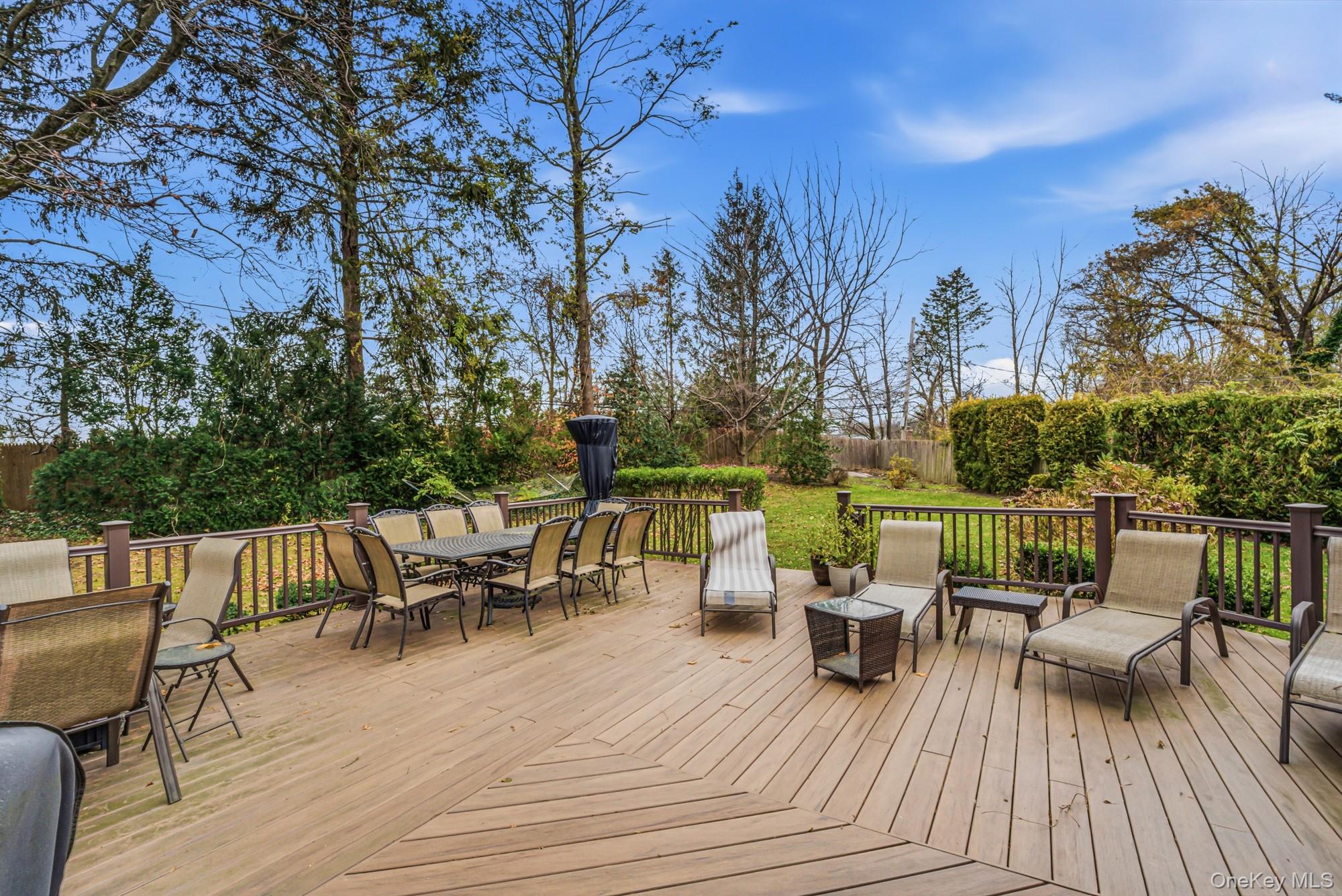 123 Robby Lane Manhasset Hills, NY 11040 - Photo 25 of 30 a view of a roof deck with table and chairs couches with wooden floor and fence