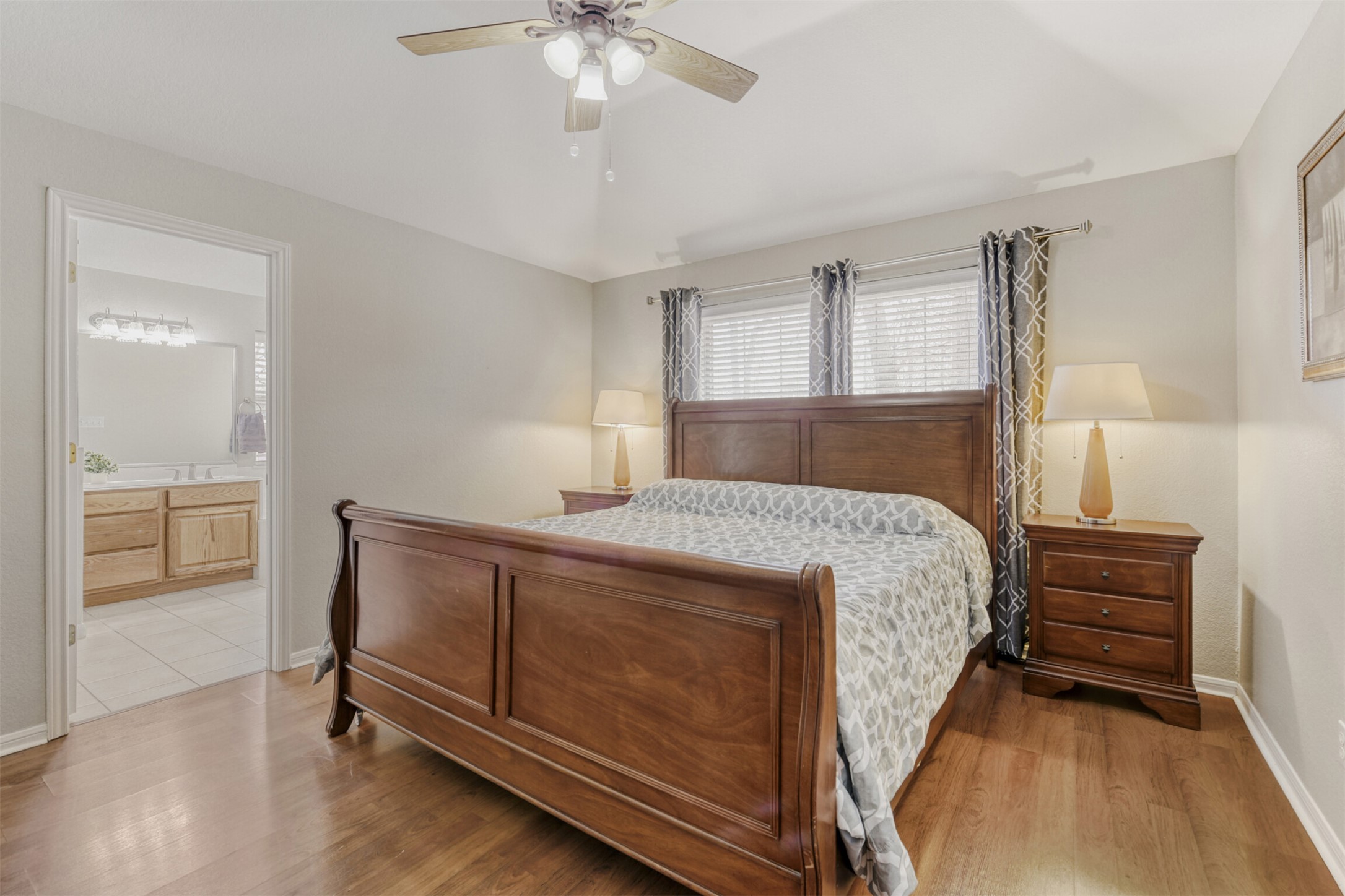 104 Spring Branch Bastrop, TX 78602 - Photo 23 of 32 Bedroom featuring light wood-style flooring, a ceiling fan, and ensuite bath