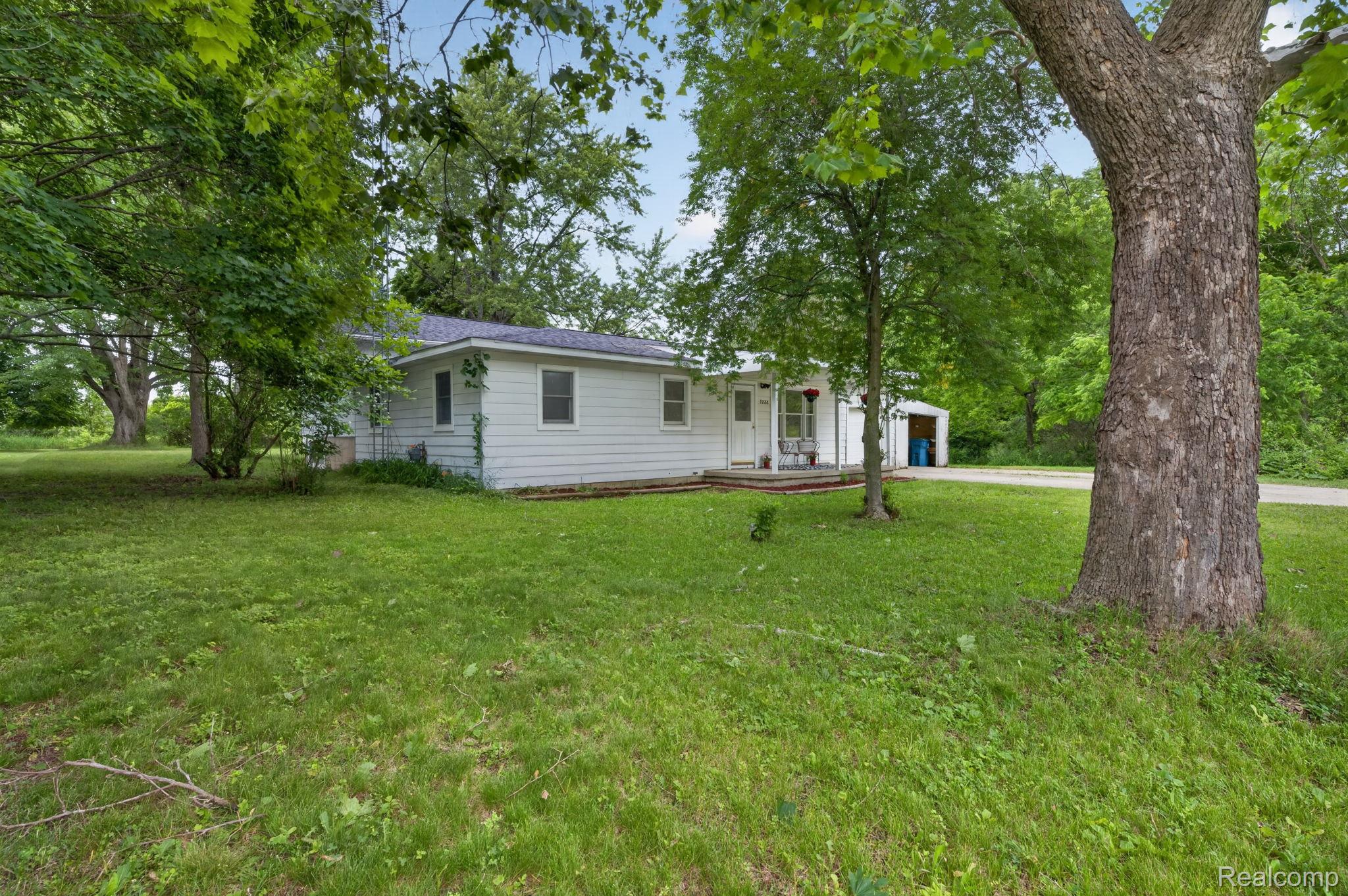 9288 Hilda Lane Flushing, MI 48433 - Photo 7 of 50 Expansive green lawn surrounds a white siding residence with a covered front porch