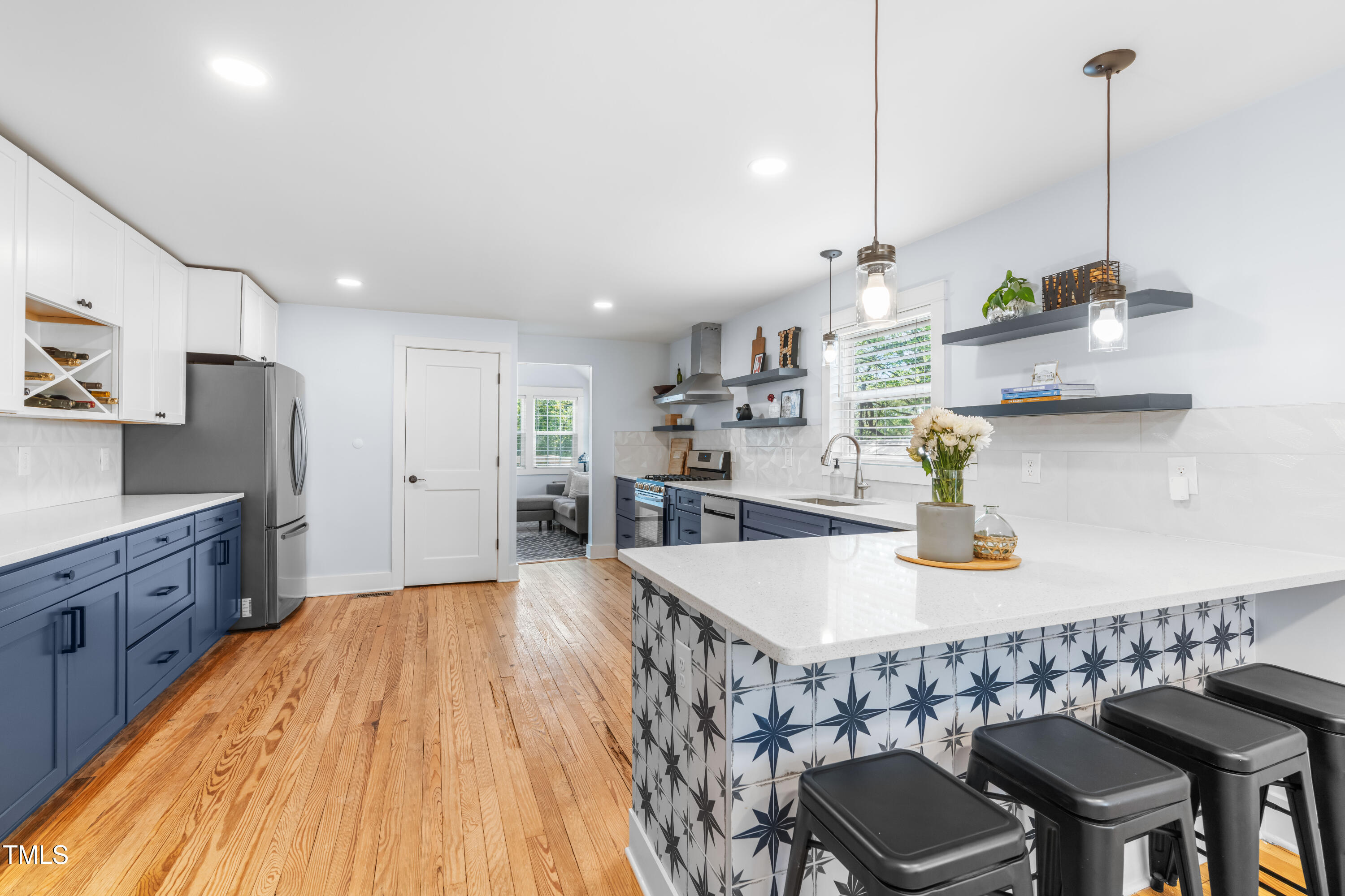 1023 Kent Street Durham, NC 27707 - Photo 15 of 40 a kitchen with stainless steel appliances granite countertop a sink a stove a dining table and chairs with wooden floor
