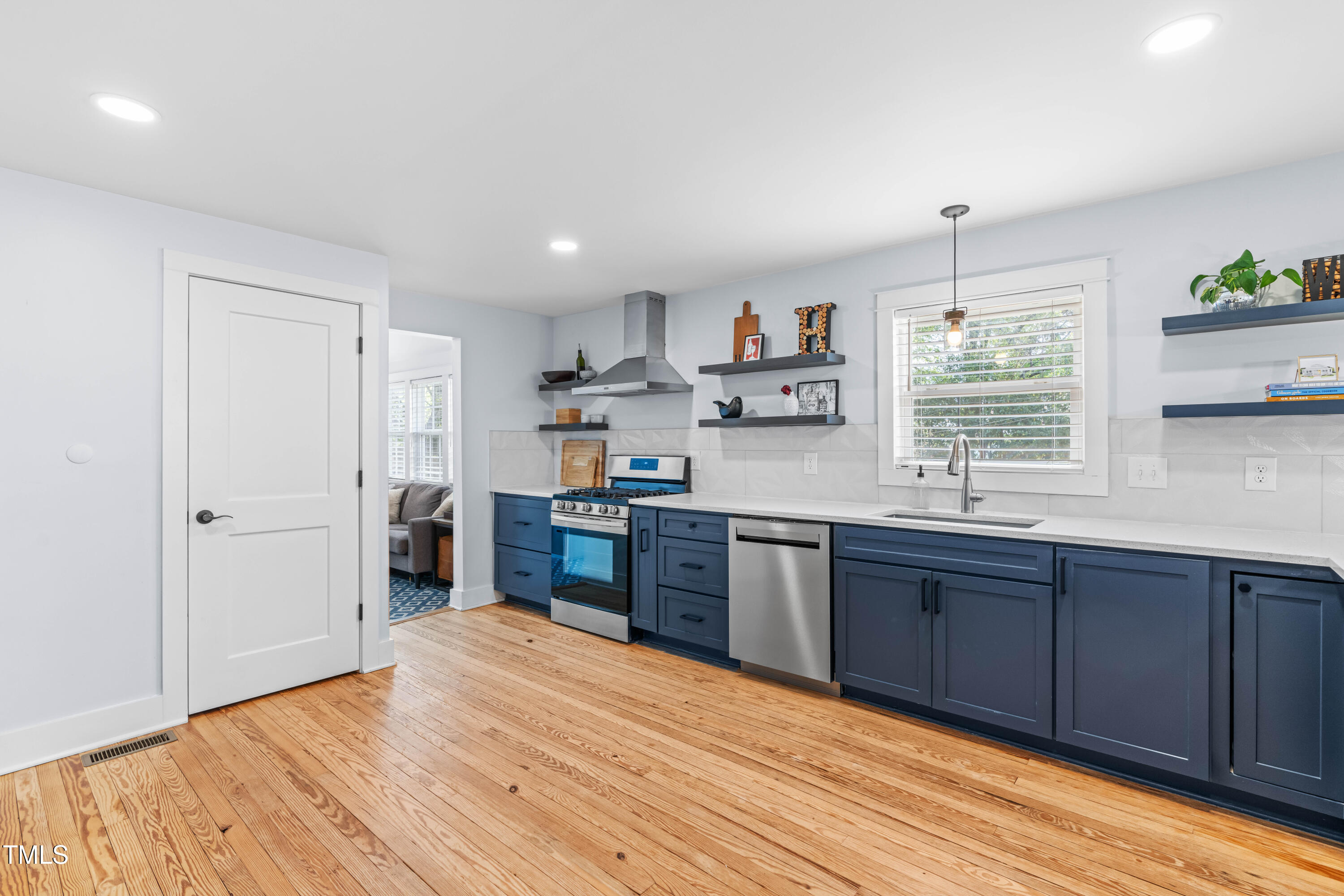 1023 Kent Street Durham, NC 27707 - Photo 17 of 40 a kitchen with stainless steel appliances granite countertop a sink cabinets and wooden floor