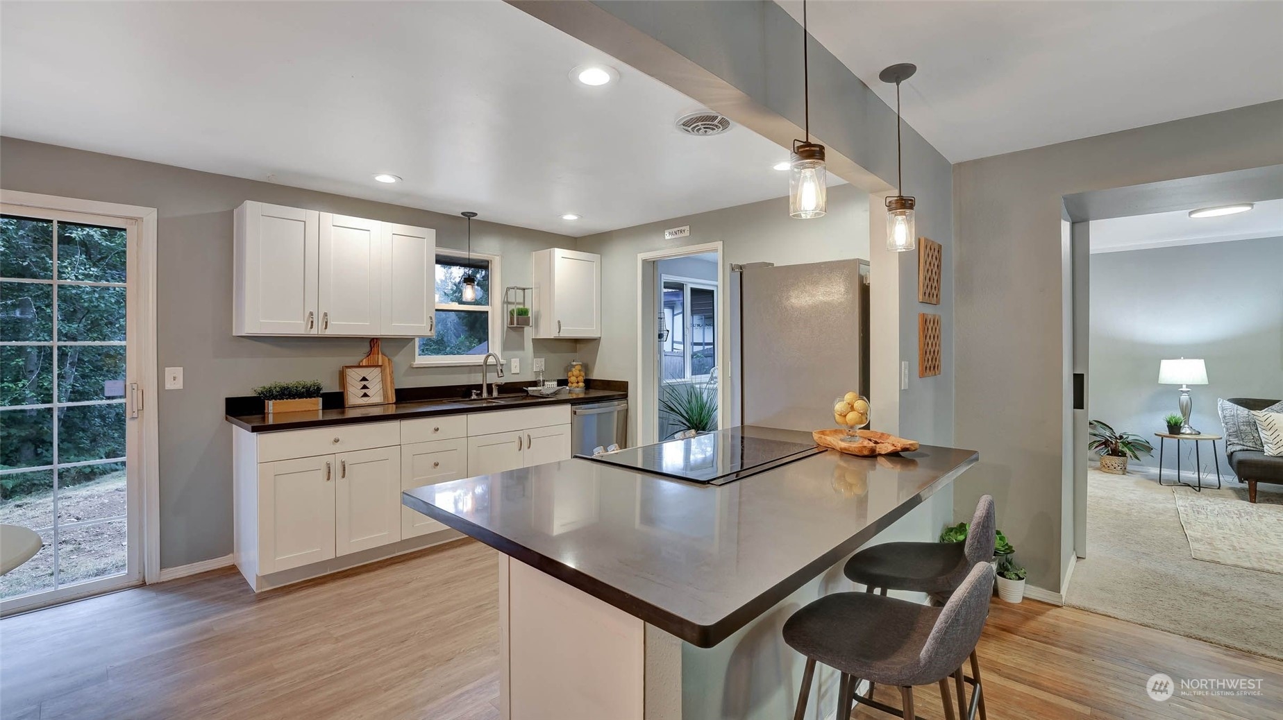 14333 165th Place Southeast Renton, WA 98059 - Photo 7 of 36 a kitchen with stainless steel appliances granite countertop a stove a refrigerator a sink a dining table and chairs with wooden floor