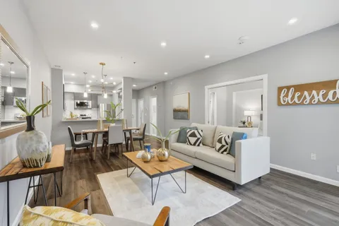 a living room with furniture kitchen view and a table