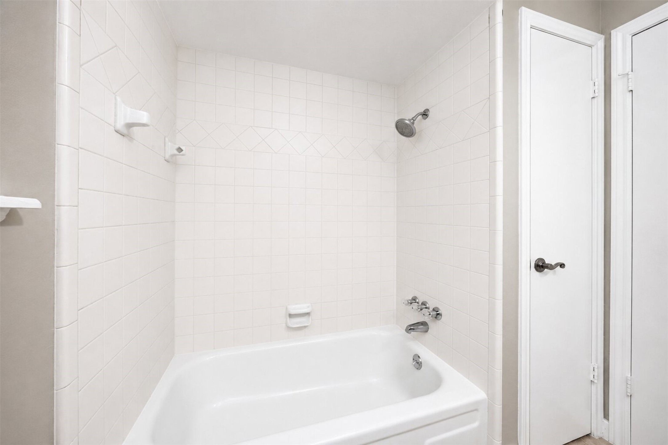 15414 Ripplestream Drive Houston, TX 77068 - Photo 32 of 41 Traditional shower and tub combo with classic white tile, and an adjacent linen closet.