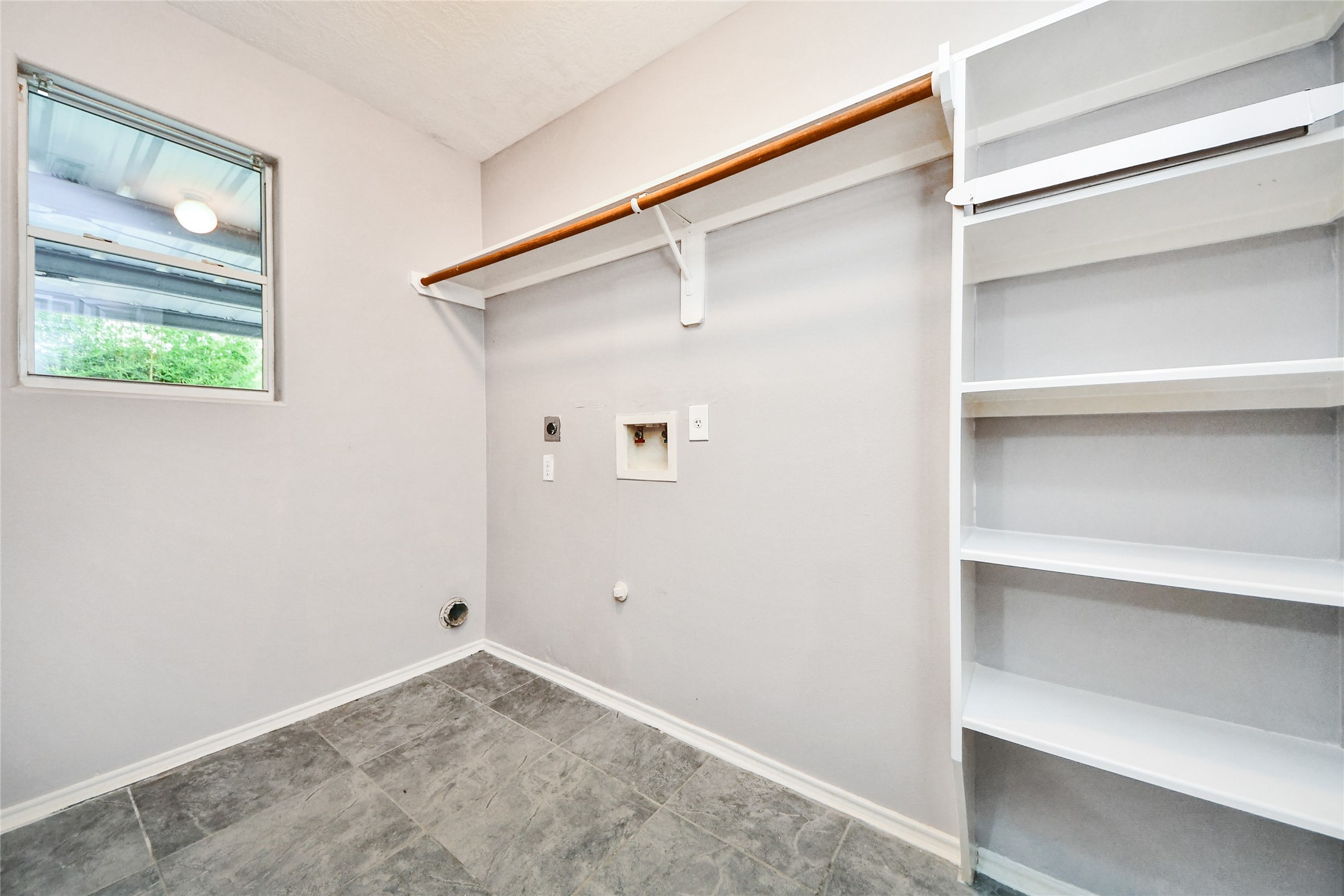 24019 Kingbriar Drive Spring, TX 77373 - Photo 26 of 41 This functional laundry area provides built-in shelving and hanging rods for organization, making chores a breeze for the busy household.