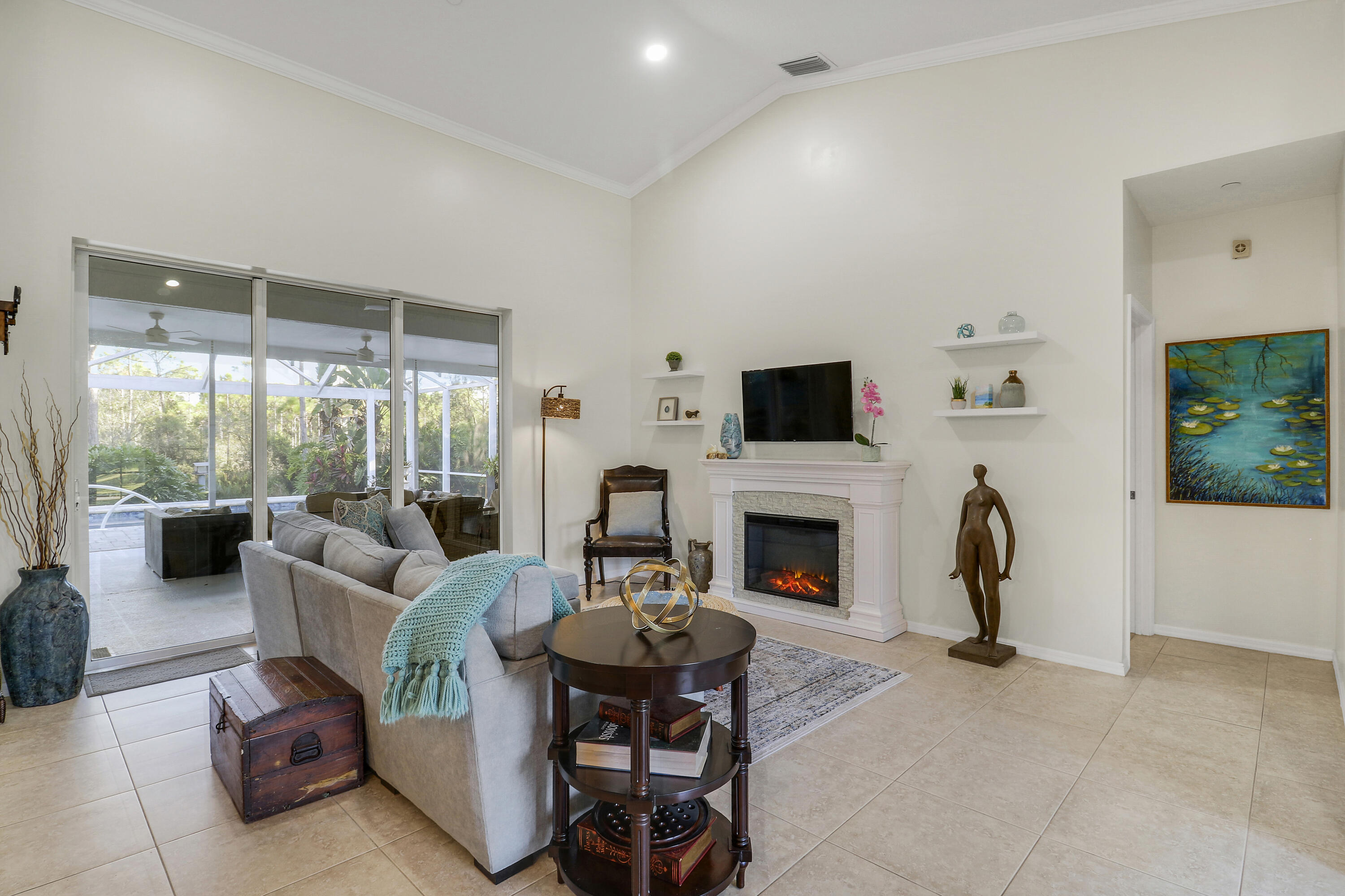 149 Southeast Ashley Oaks Way Stuart, FL 34997 - Photo 12 of 47 a living room with furniture a fireplace and a flat screen tv