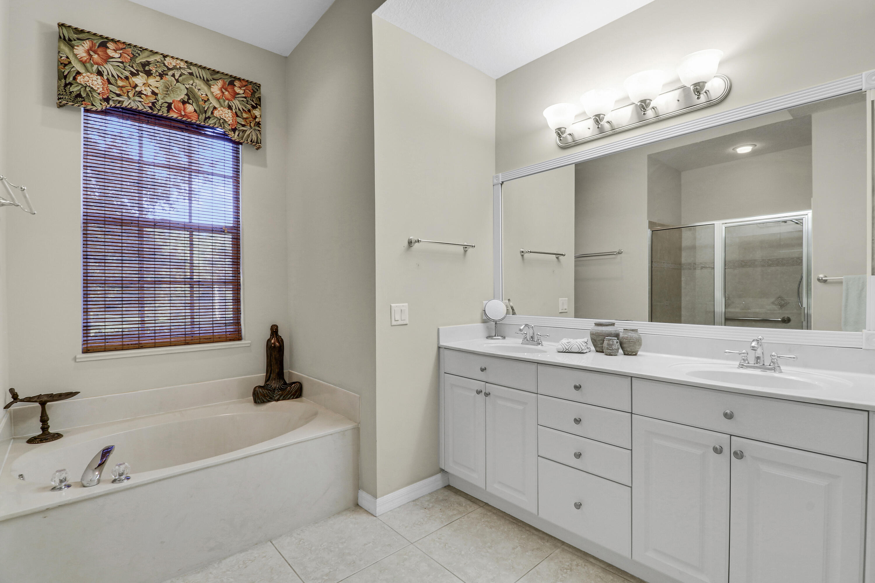 149 Southeast Ashley Oaks Way Stuart, FL 34997 - Photo 29 of 47 a bathroom with a tub a sink and mirror