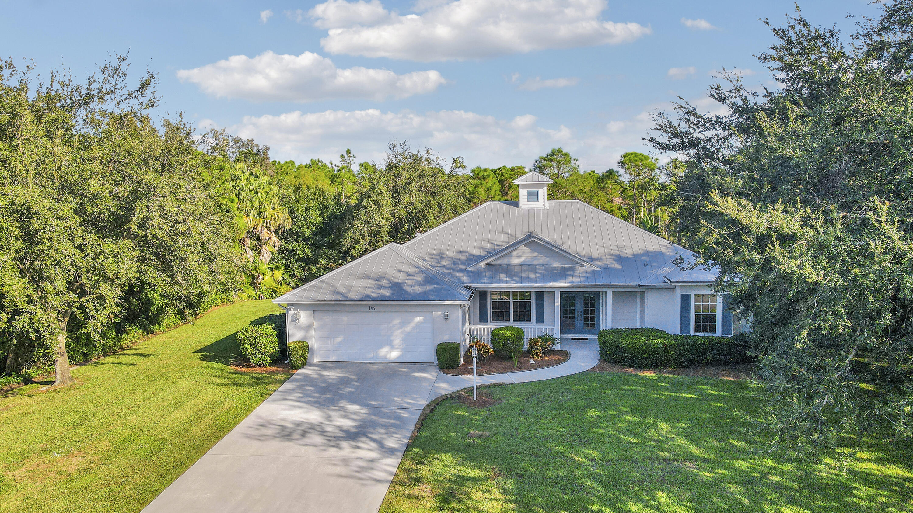 149 Southeast Ashley Oaks Way Stuart, FL 34997 - Photo 5 of 47 a front view of a house with garden