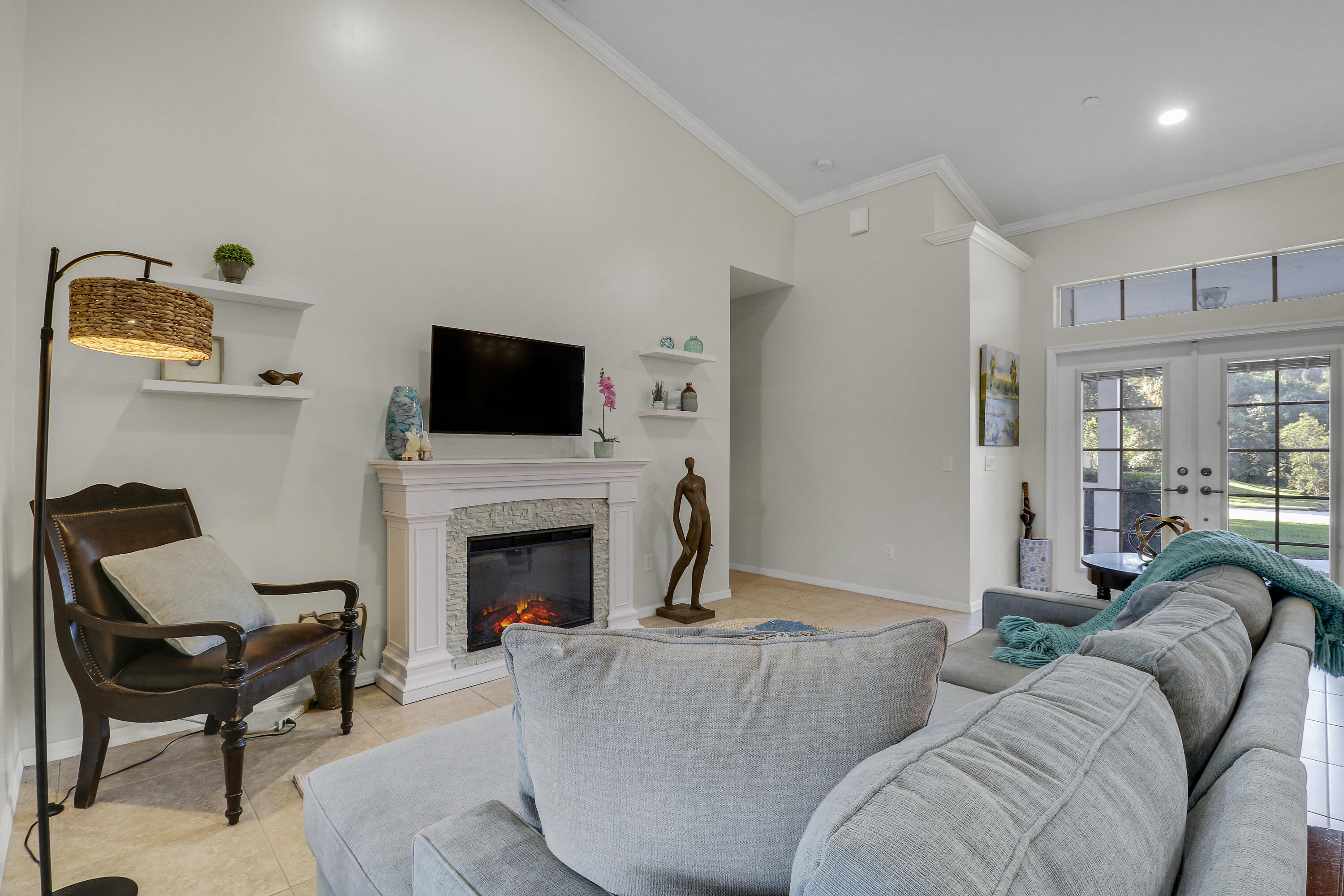 149 Southeast Ashley Oaks Way Stuart, FL 34997 - Photo 10 of 47 a living room with furniture a fireplace and a flat screen tv
