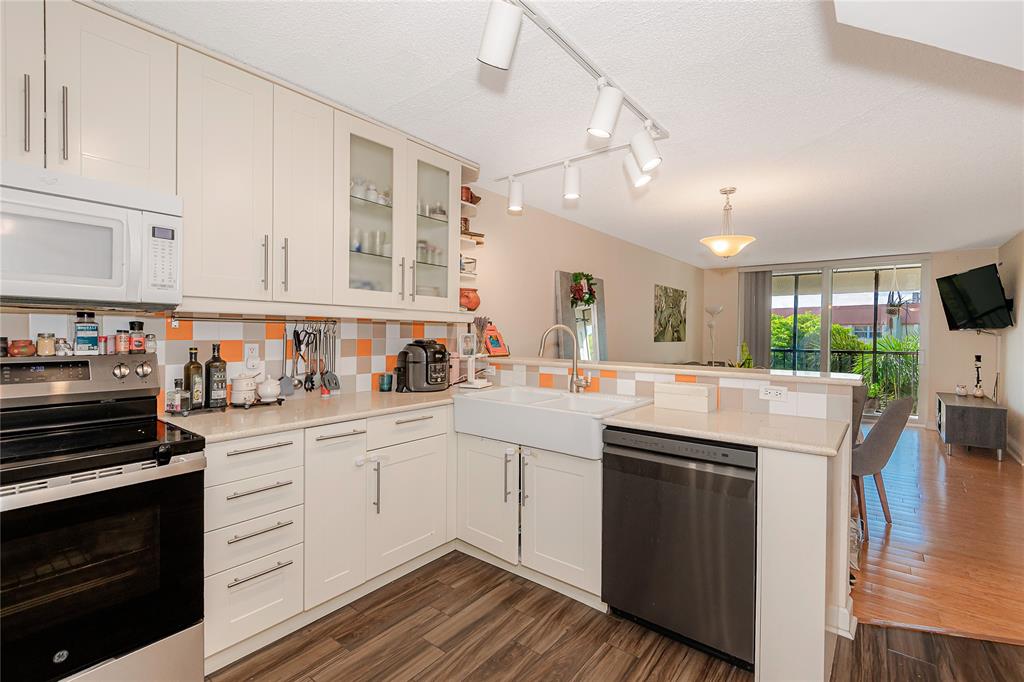 5300 Northeast 24th Terrace, Unit 512 Fort Lauderdale, FL 33308 - Photo 19 of 29 a kitchen with kitchen island granite countertop a sink cabinets and stainless steel appliances