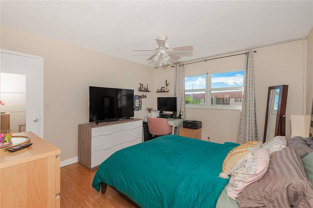 5300 Northeast 24th Terrace, Unit 512 Fort Lauderdale, FL 33308 - Photo 9 of 29 a bedroom with a bed and a flat screen tv