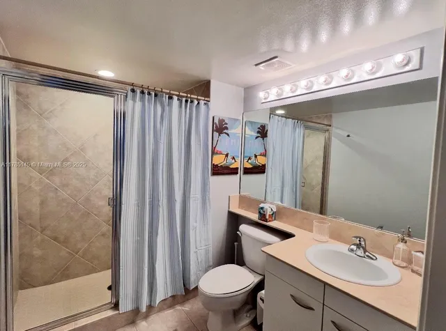 a bathroom with a sink a toilet a mirror and shower