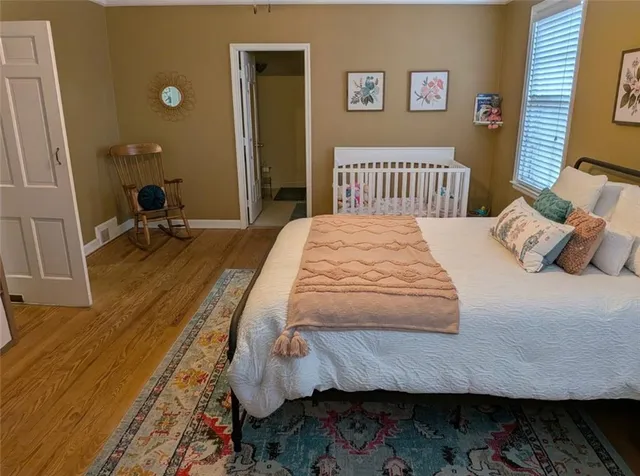 a bedroom with a bed and wooden floor