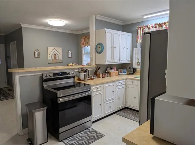 a kitchen with cabinets appliances and wooden floor
