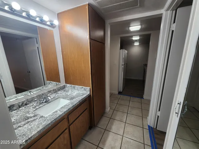 a bathroom with a granite countertop sink and a mirror