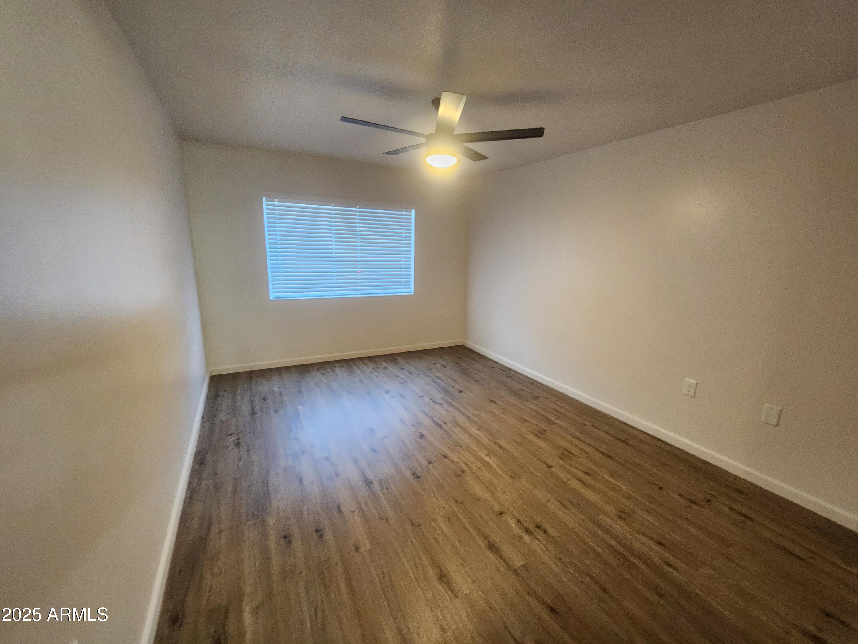 3033 East Devonshire Avenue, Unit 1028 Phoenix, AZ 85016 - Photo 12 of 27 a view of an empty room with wooden floor