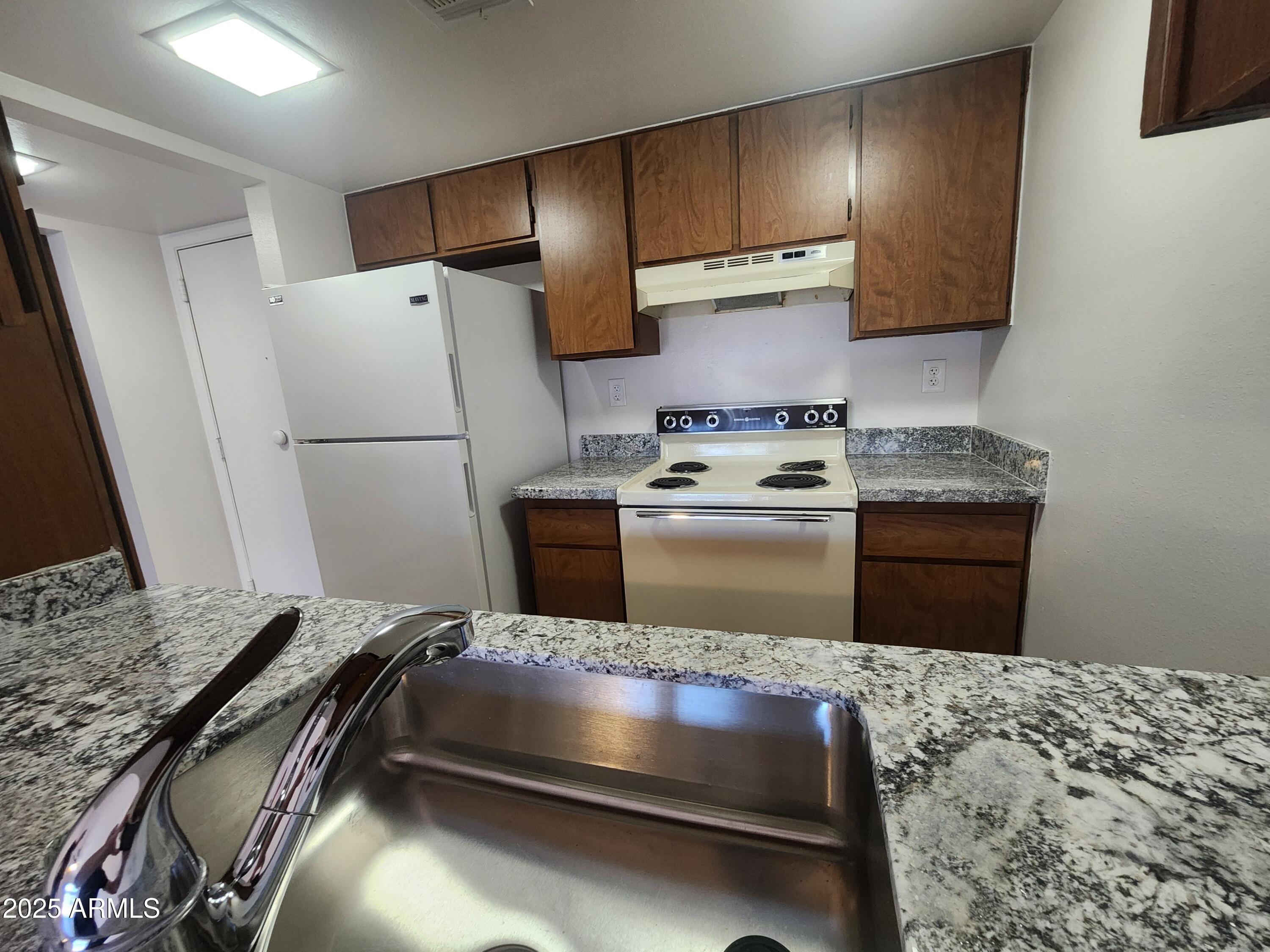 3033 East Devonshire Avenue, Unit 1028 Phoenix, AZ 85016 - Photo 2 of 27 a kitchen with a sink stove and refrigerator