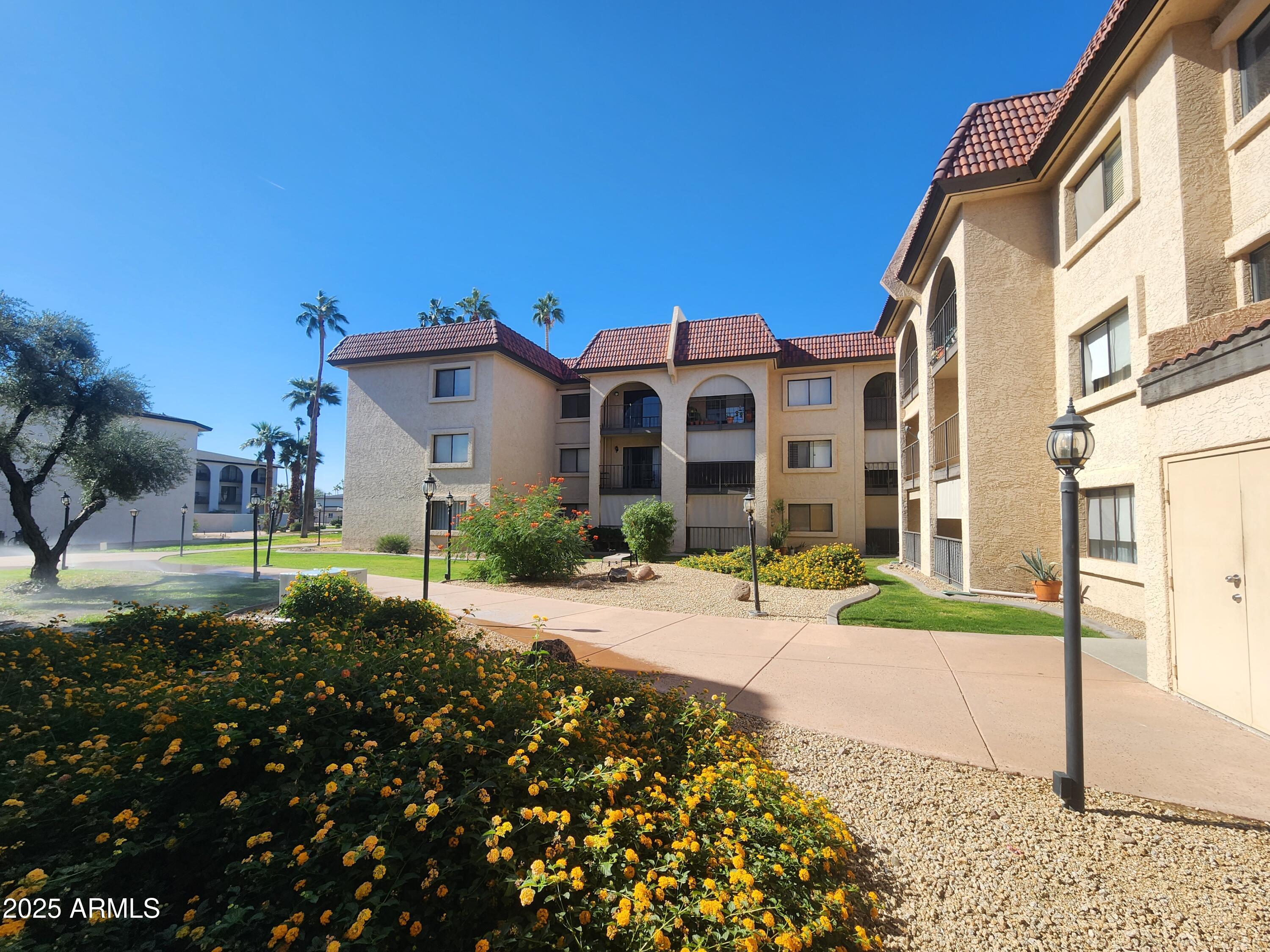 3033 East Devonshire Avenue, Unit 1028 Phoenix, AZ 85016 - Photo 23 of 27 a view of a brick house with a yard