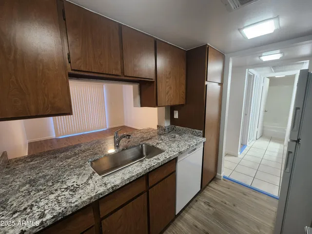a kitchen with granite countertop wooden cabinets and a stainless steel appliances