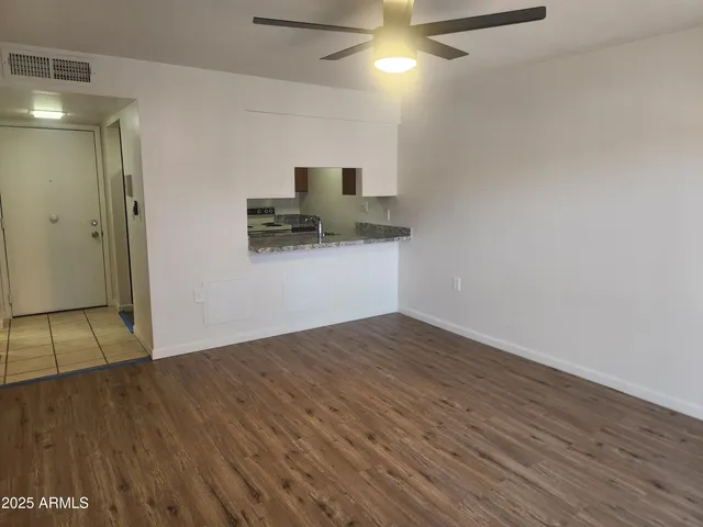 a view of empty room with wooden floor