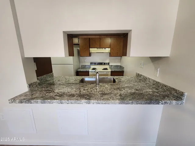 a kitchen with a sink a counter top space and cabinets