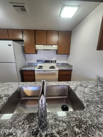 a kitchen with a stove a refrigerator and a sink
