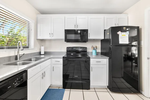a kitchen with a sink a refrigerator and cabinets