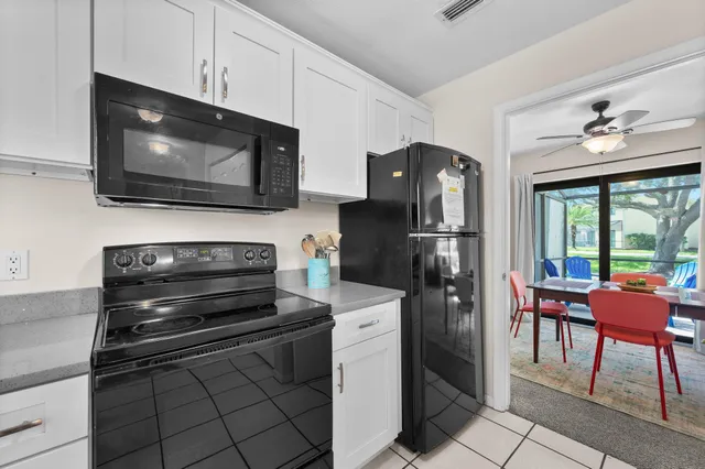 a kitchen with stainless steel appliances kitchen island granite countertop a refrigerator stove and microwave
