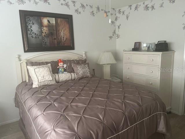 9430 Nakoma Way, Unit 12 Weeki Wachee, FL 34613 - Photo 12 of 20 a bedroom with a bed and a lamp on dresser