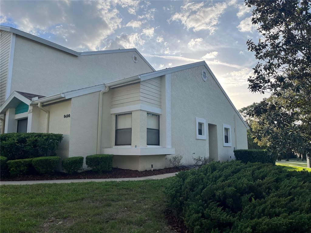 9430 Nakoma Way, Unit 12 Weeki Wachee, FL 34613 - Photo 2 of 20 a front view of a house with a yard and garage
