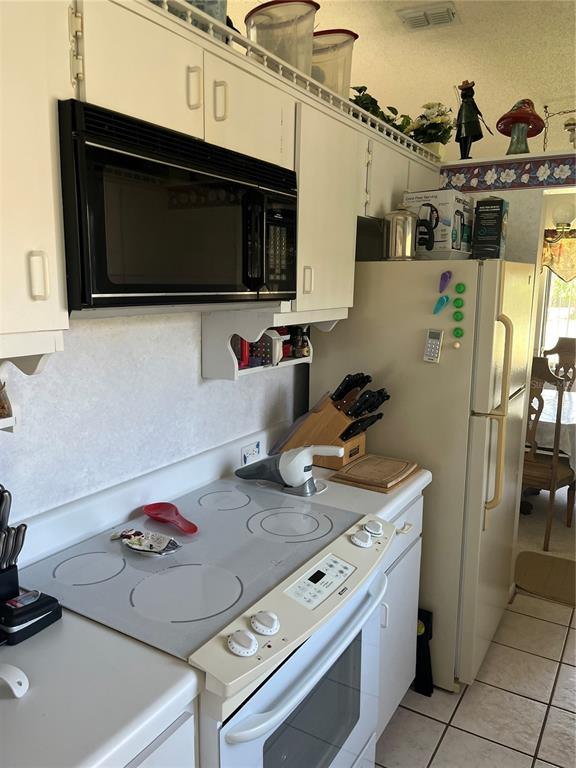 9430 Nakoma Way, Unit 12 Weeki Wachee, FL 34613 - Photo 8 of 20 a kitchen with a stove and a microwave