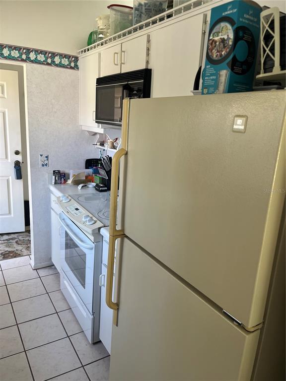 9430 Nakoma Way, Unit 12 Weeki Wachee, FL 34613 - Photo 10 of 20 a kitchen with stainless steel appliances a refrigerator sink and stove