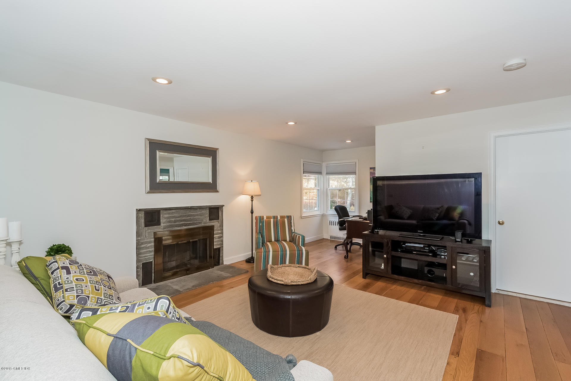 84 Cognewaugh Road Cos Cob, CT 06807 - Photo 4 of 18 a living room with furniture a flat screen tv and a fireplace