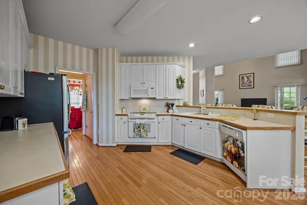 a kitchen with stainless steel appliances granite countertop a refrigerator a stove top oven and a sink