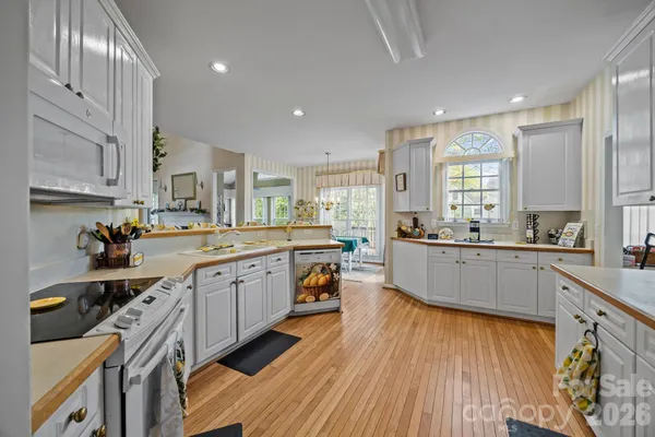 a large kitchen with stainless steel appliances granite countertop a lot of counter space and wooden floors