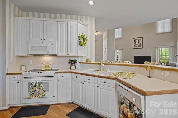 a kitchen with a sink dishwasher and cabinets with wooden floor