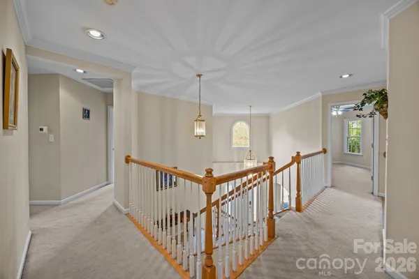 a view of a hallway with wooden floor and windows